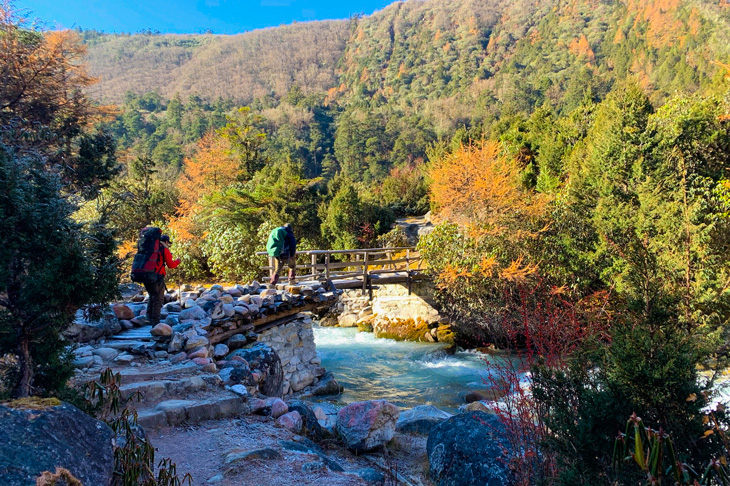 Trekkers crossing river